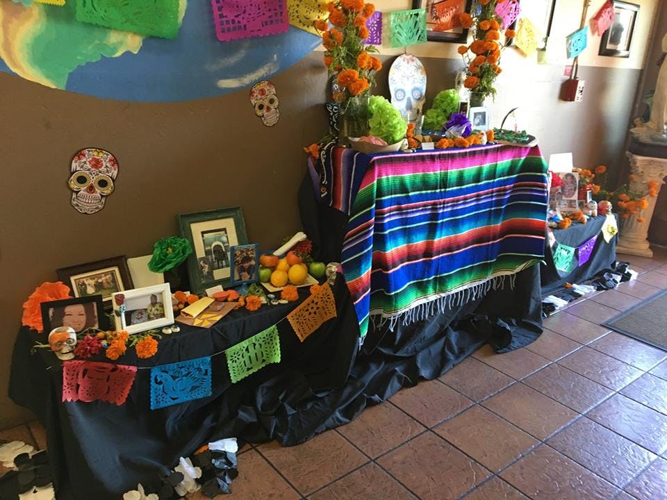 Day of the Dead altar with photos, flowers, and fruit