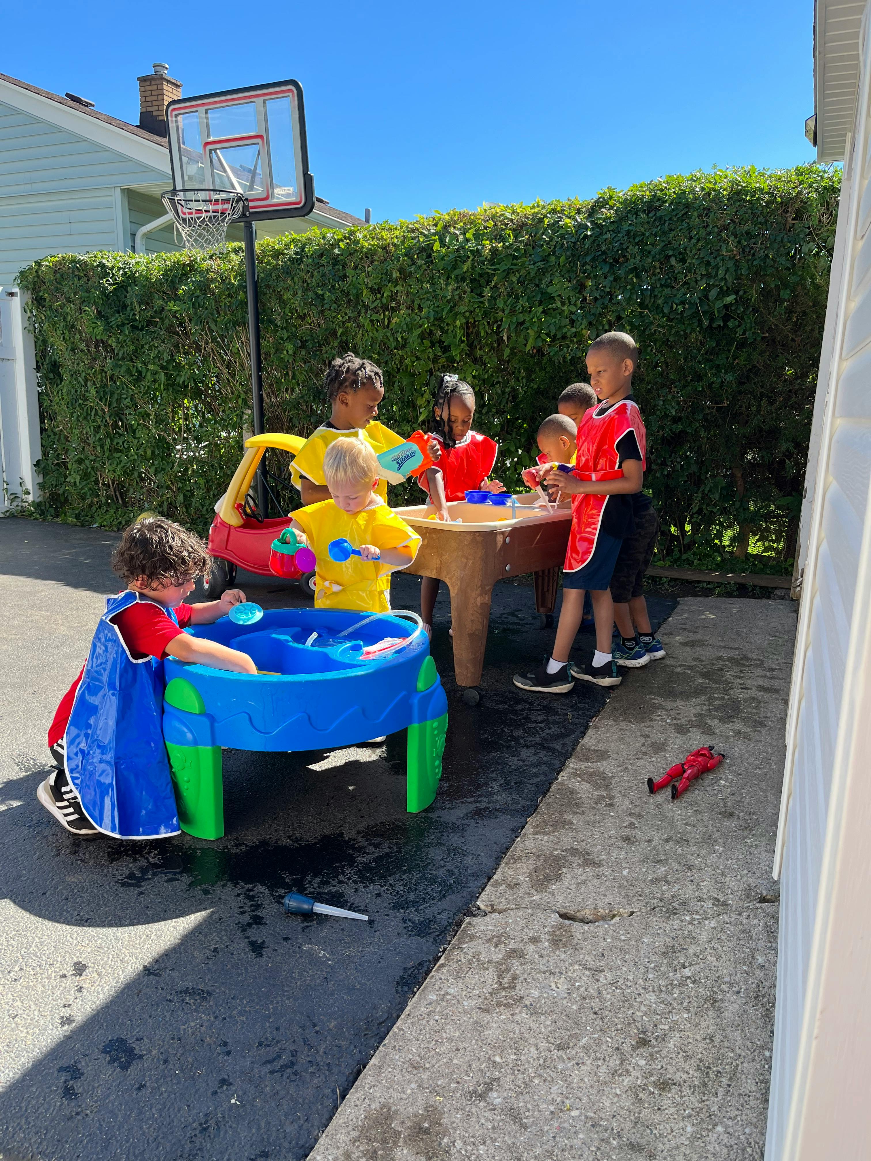 Children playing with water tables outdoors