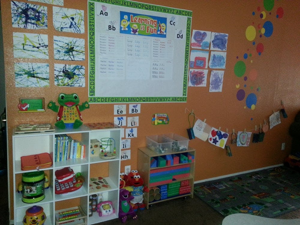 Classroom with children's artwork on the walls and shelves with toys