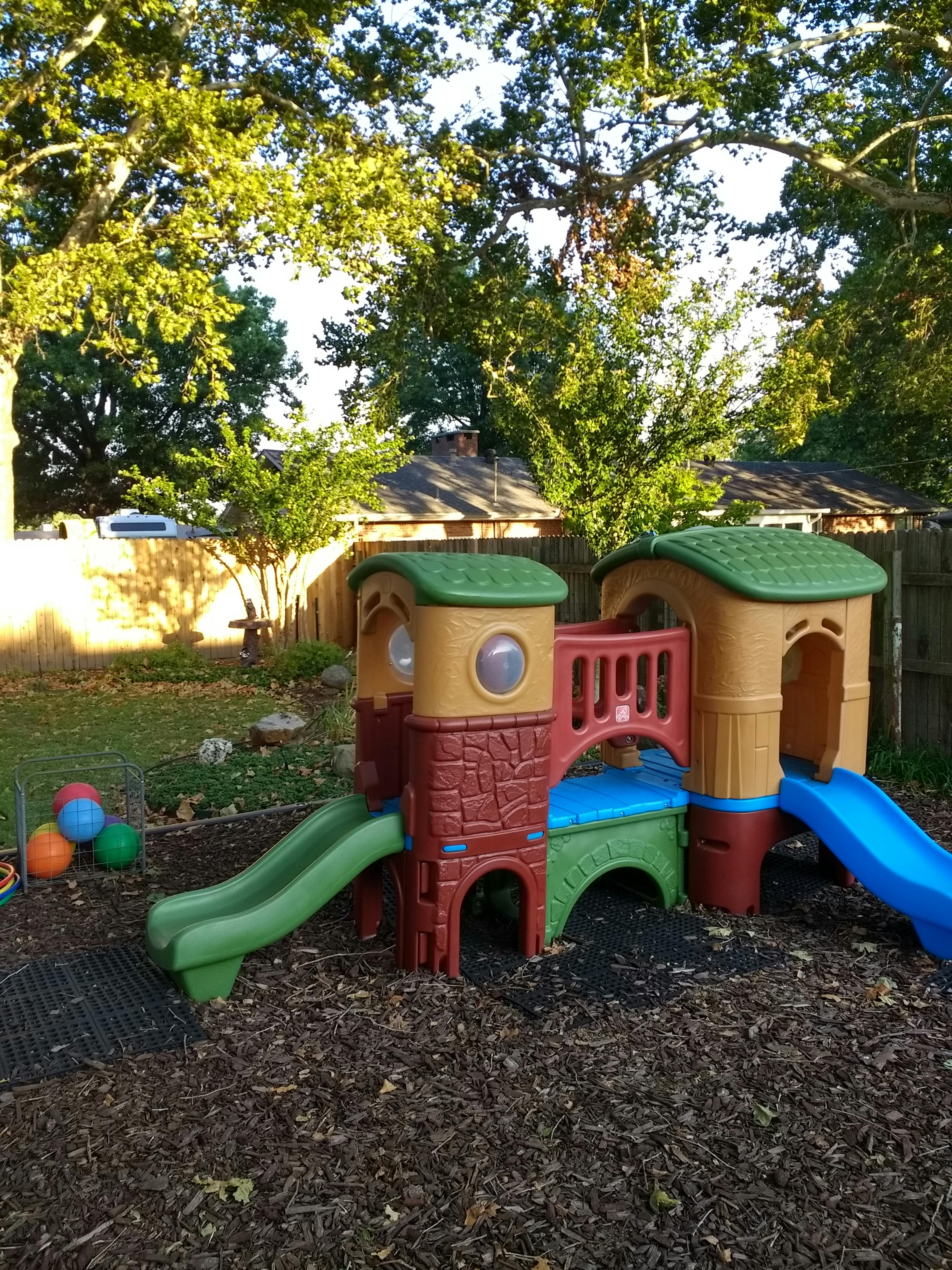 Colorful plastic playground structure with slides in a backyard