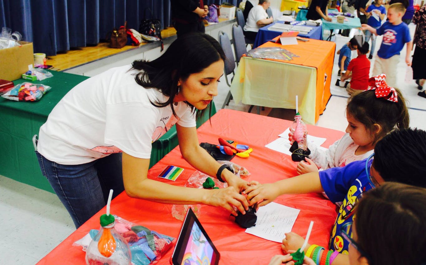Person helping children with an activity at a table