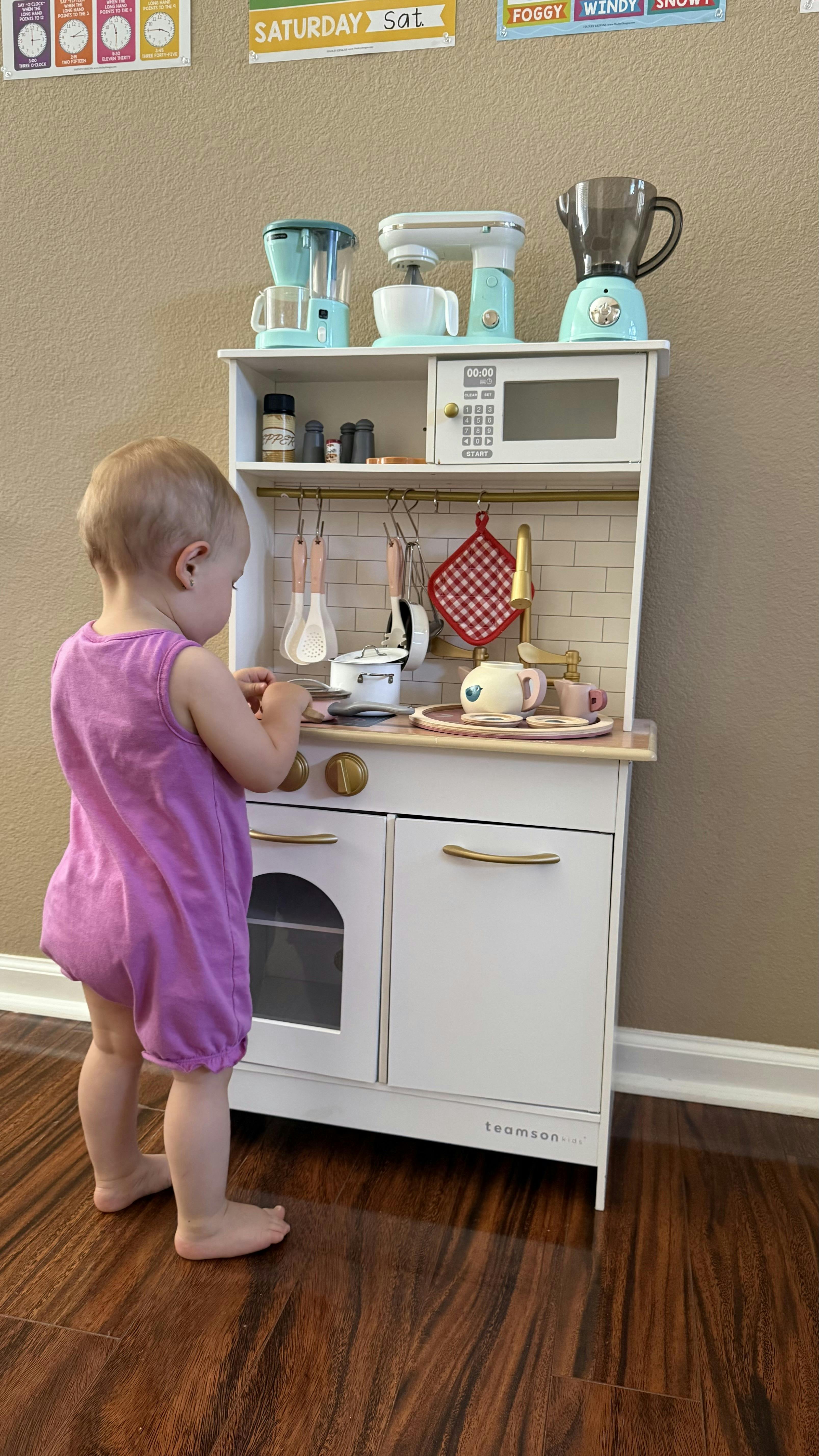 Child playing with a toy kitchen set