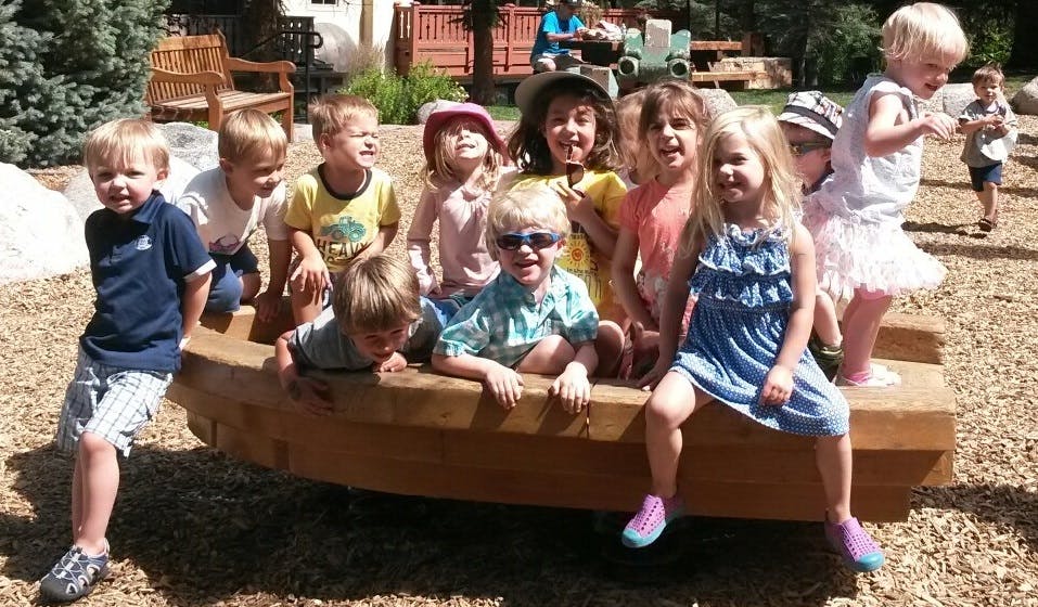 Group of children playing on a wooden structure outdoors
