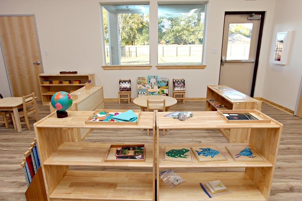 Classroom with wooden shelves, tables, and chairs