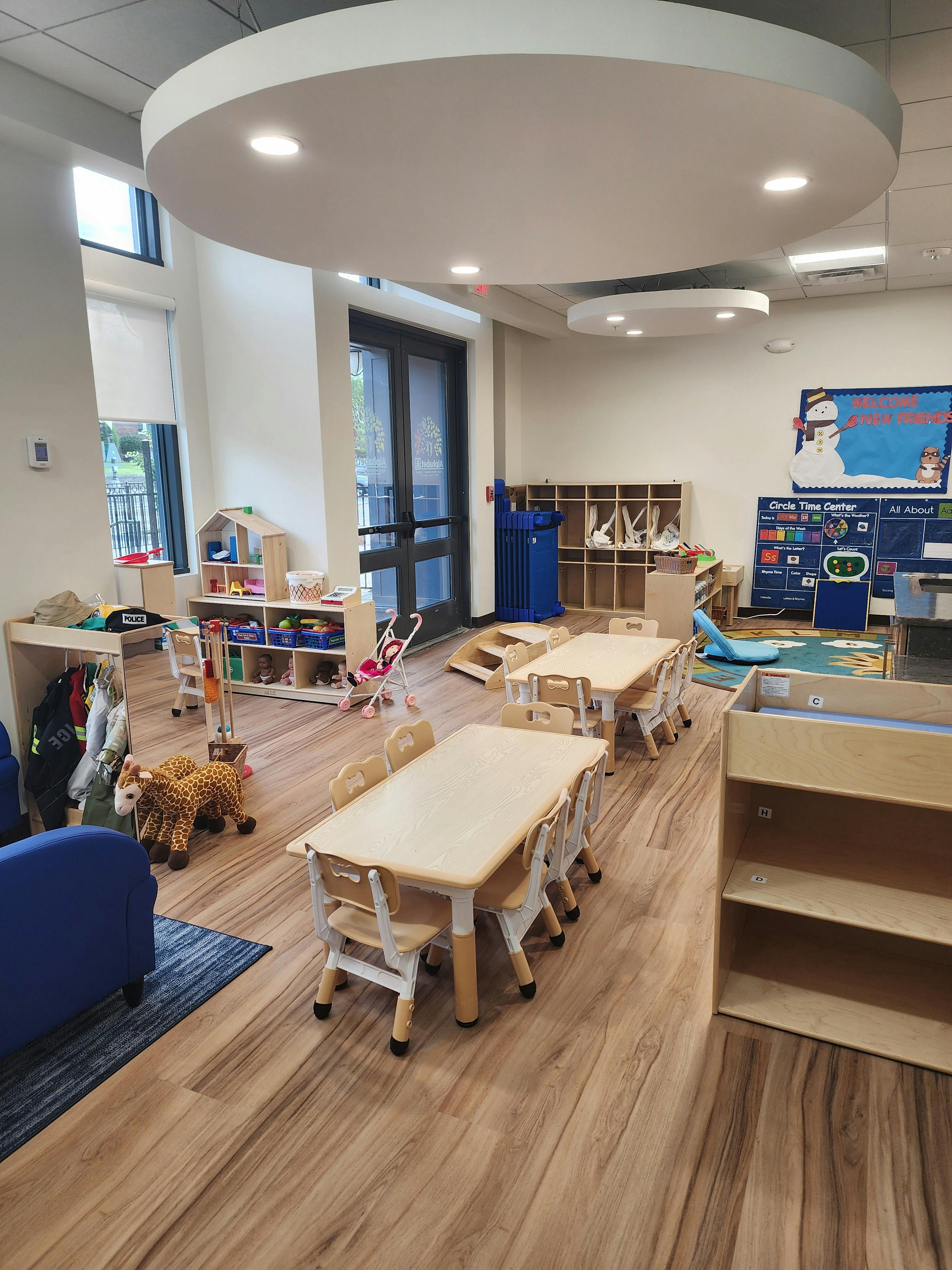 Classroom with small tables and chairs, shelves, and a calendar display