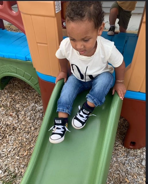 Child sitting on a green slide