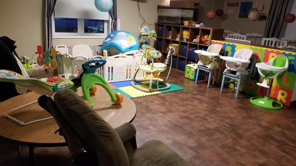 Room with multiple baby high chairs, play mats, and baby activity centers