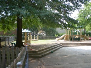 Outdoor playground with wooden structures, slide, and steps