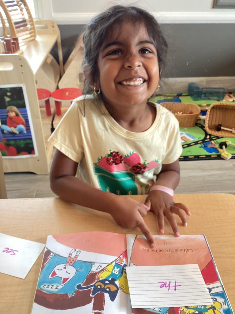 Child pointing at a book on a table