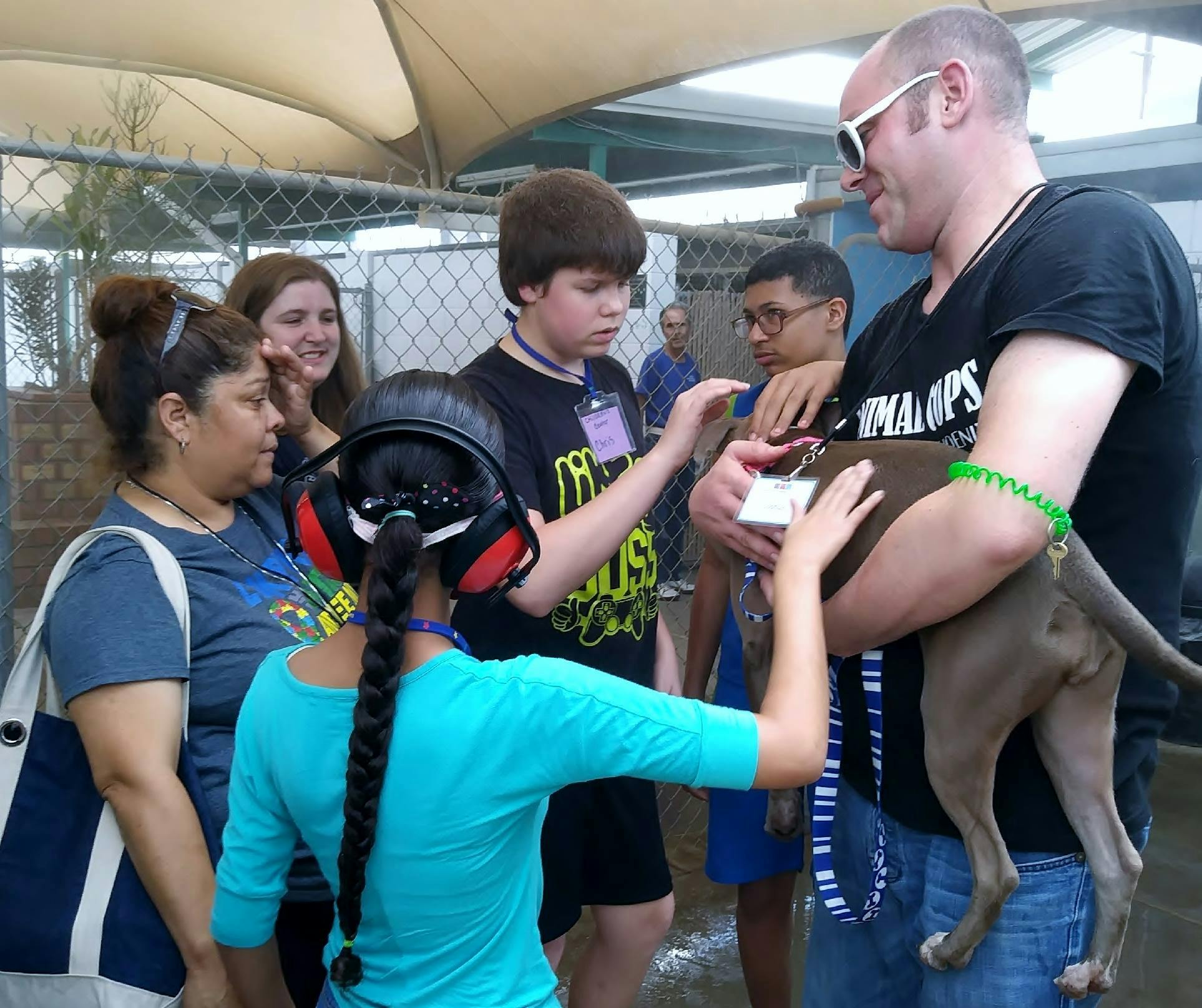 Person holding a dog while others interact with it