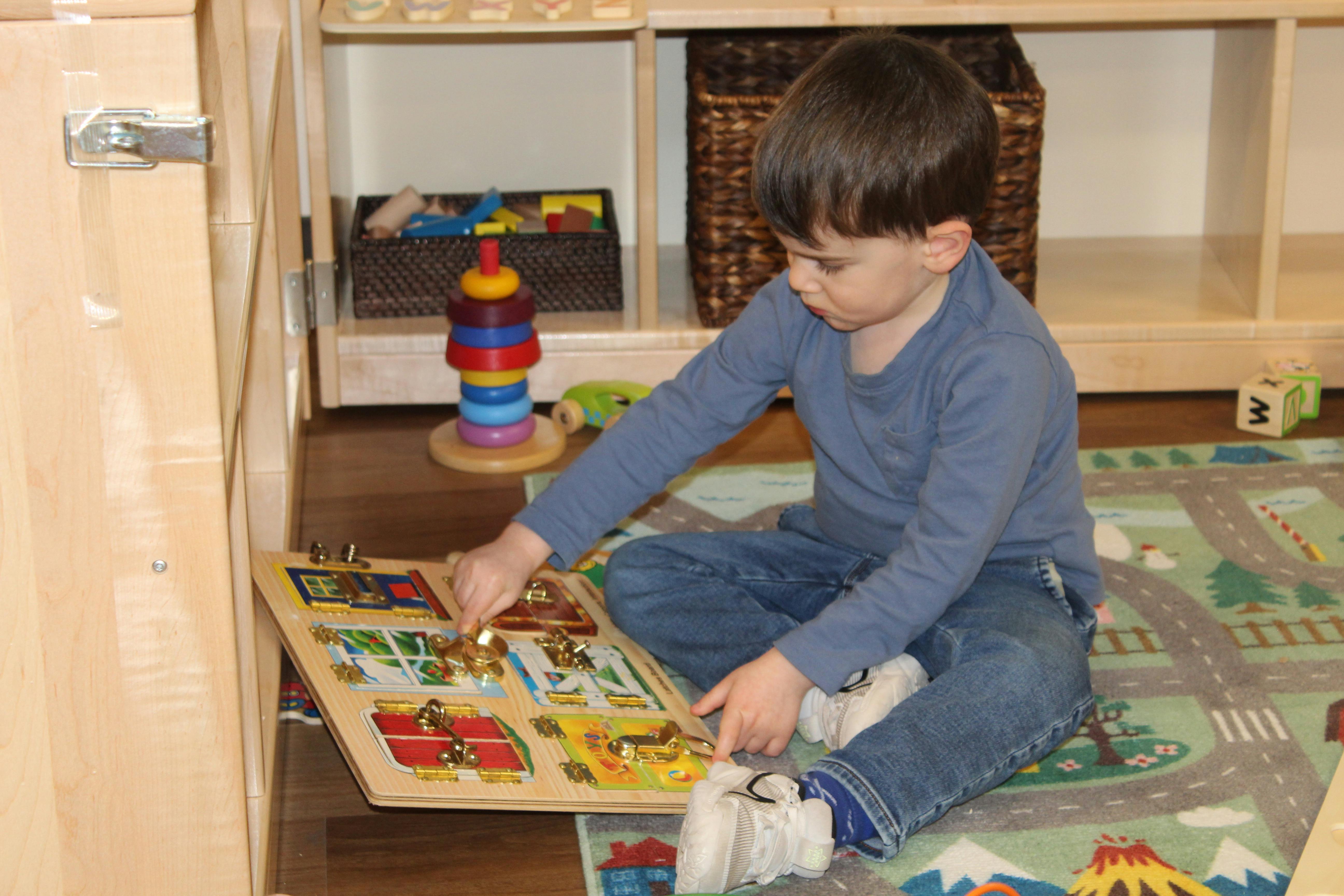 Child playing with a wooden puzzle on a rug