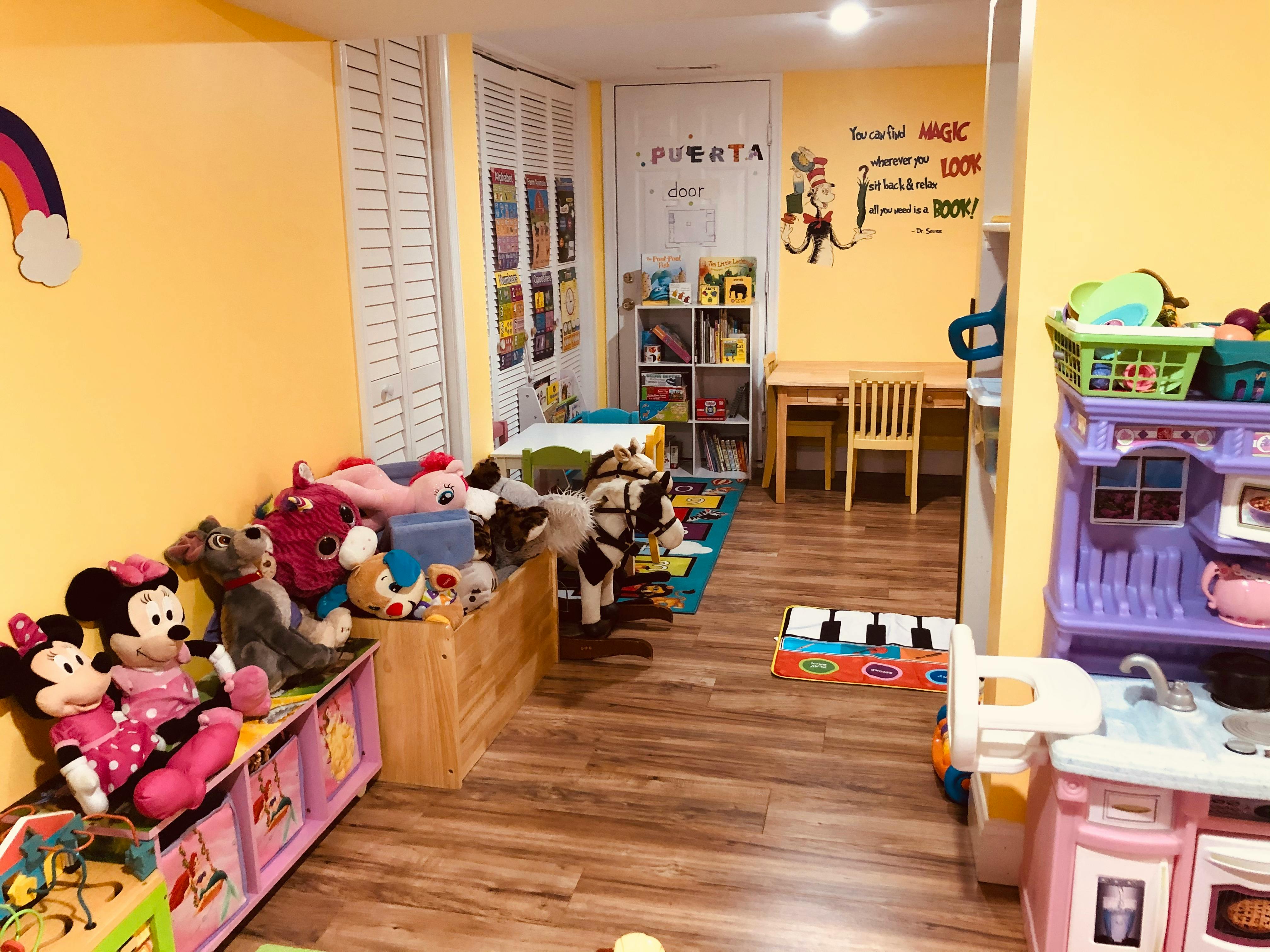 Playroom with stuffed animals, small table and chairs, and toy kitchen