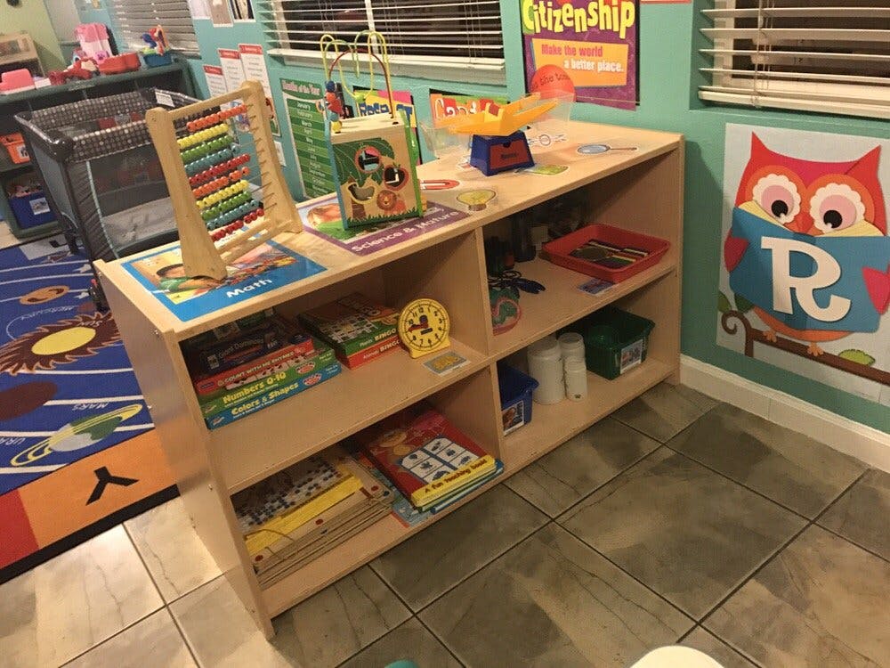 classroom with wooden shelves holding books and toys