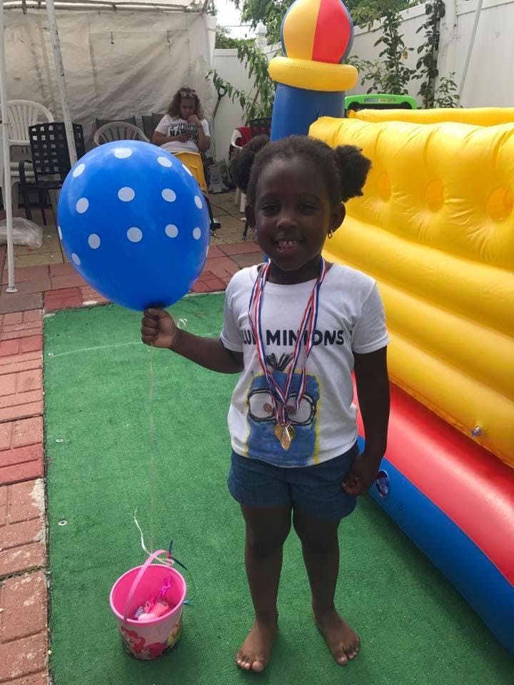 Child holding a blue polka dot balloon