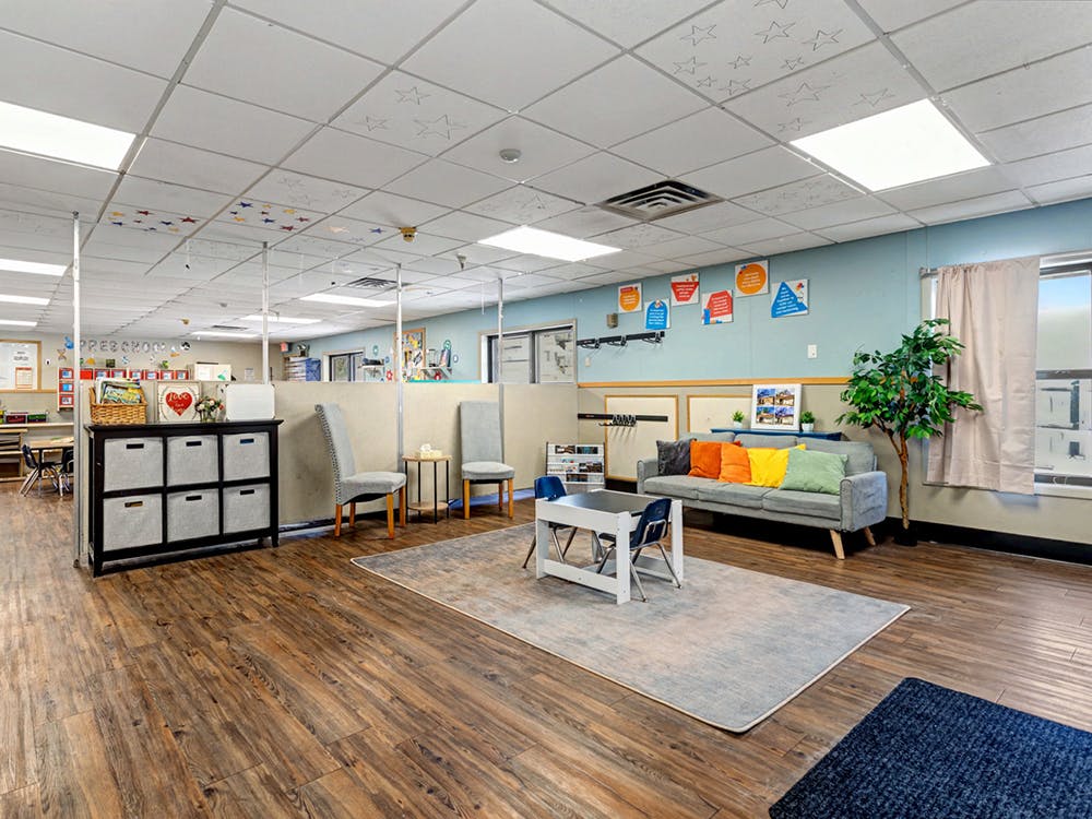 Classroom with a sitting area with a gray couch and colorful pillows