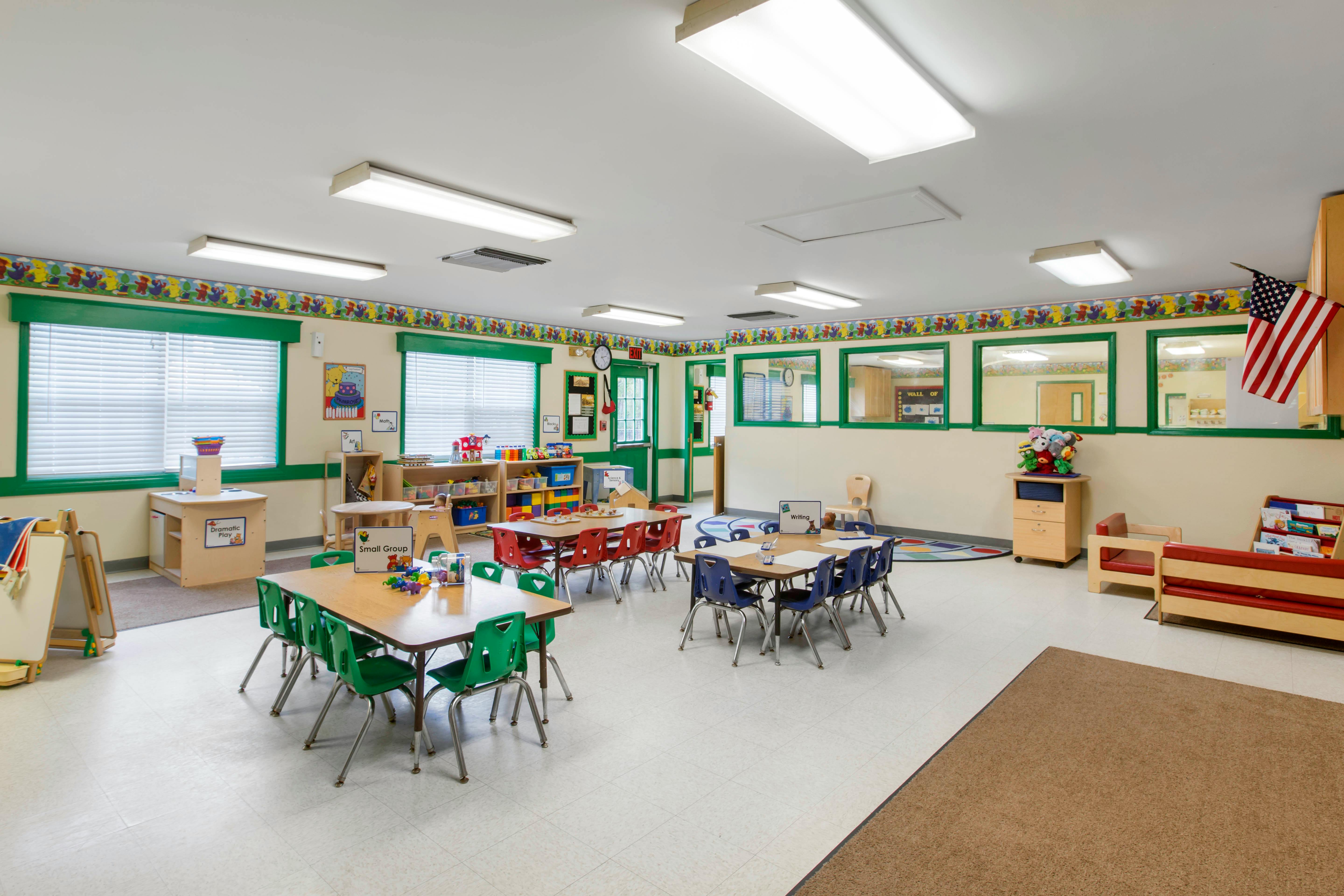 Classroom with child-sized tables and chairs, toys, and educational materials
