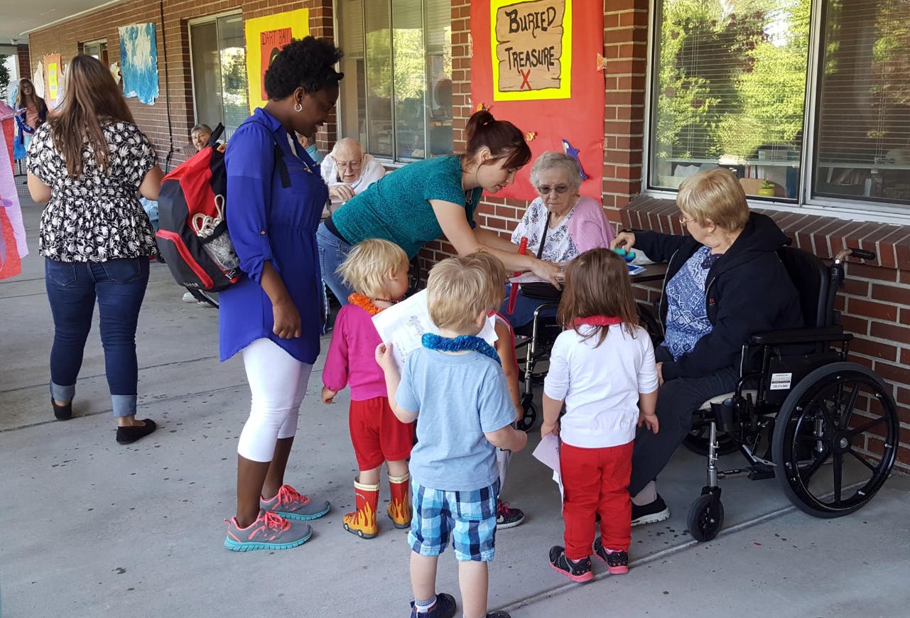 Adults and children interacting with people in wheelchairs outdoors