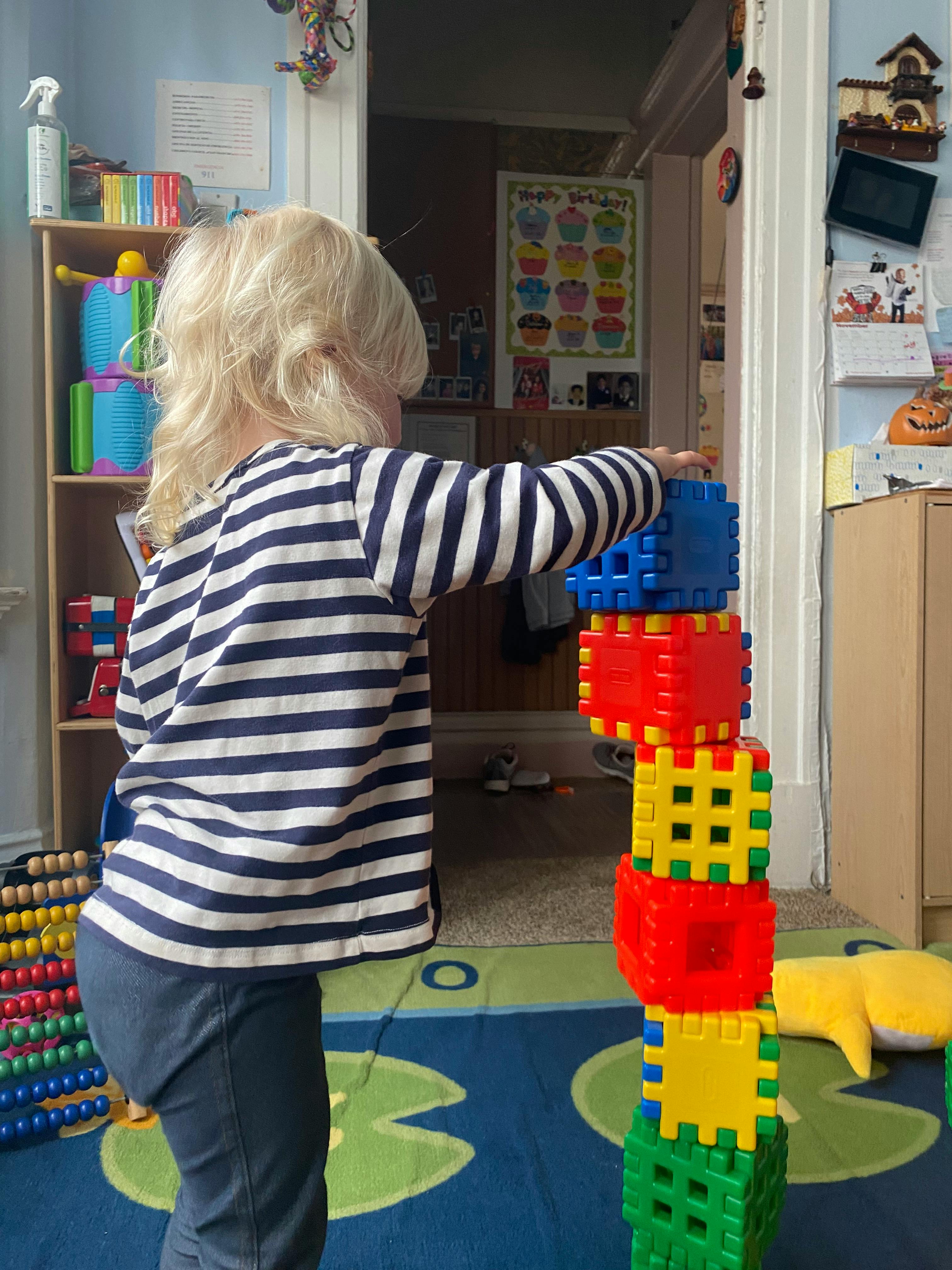 Child stacking colorful interlocking blocks