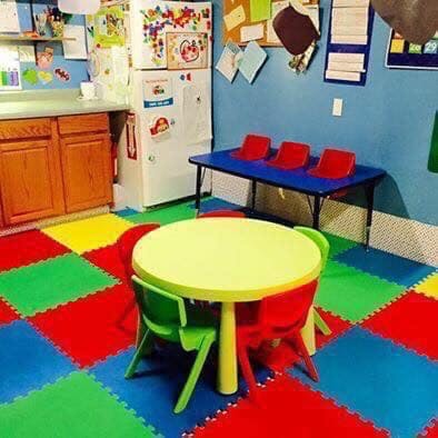 Classroom with colorful floor tiles, small tables, and chairs
