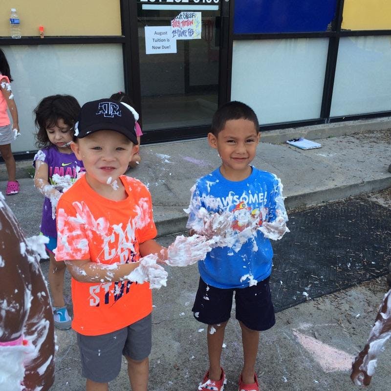 Two children covered in foam standing outdoors
