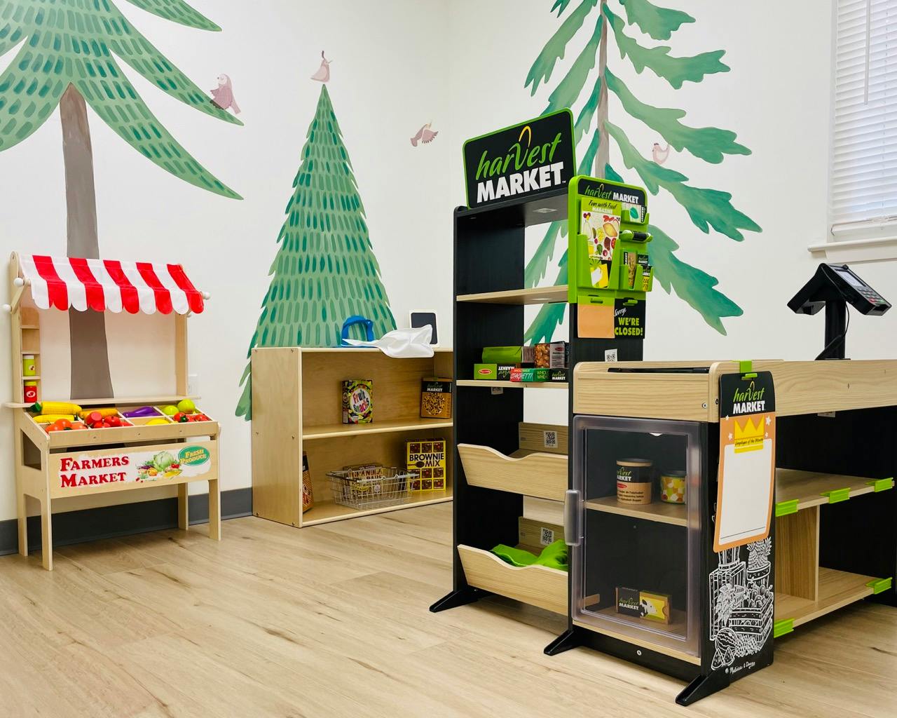 Play area with a toy farmers market stand and shelves with play food