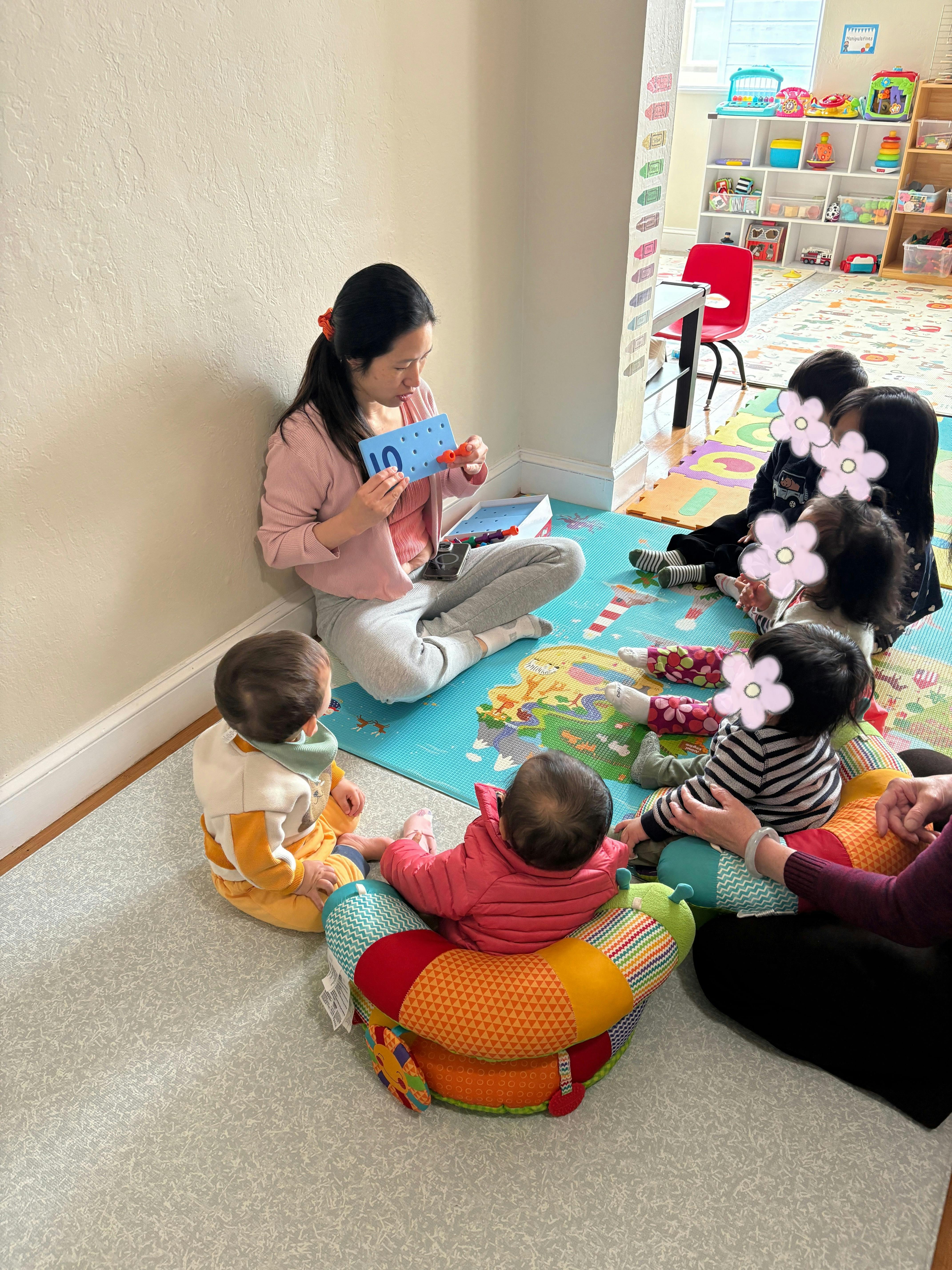Adult showing a number ten card to a group of children in a play area