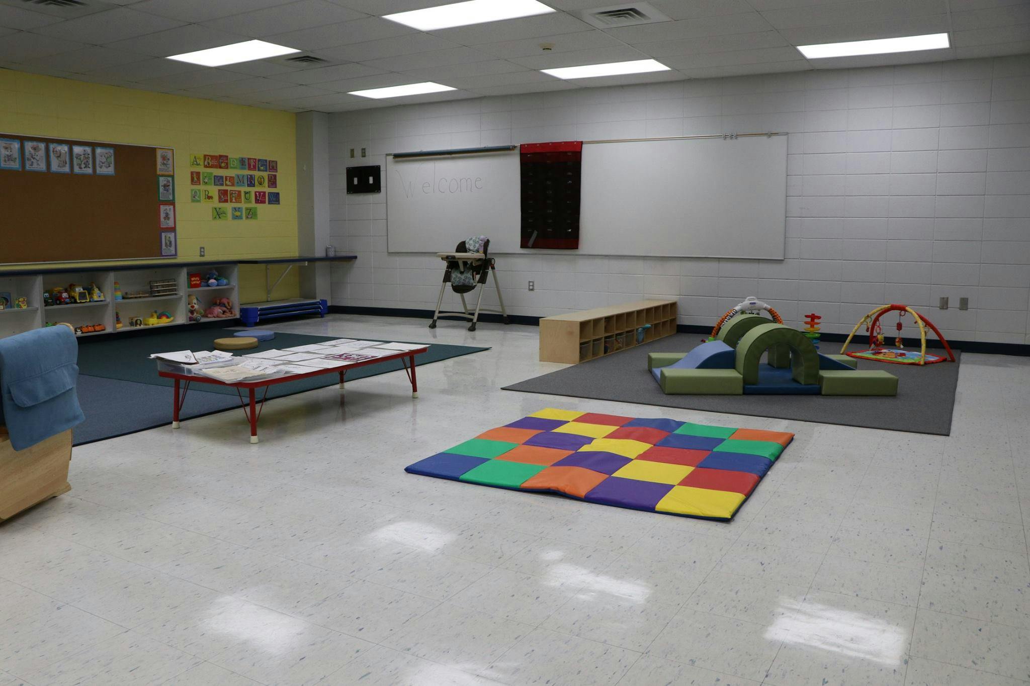 Empty classroom with play mats and small furniture