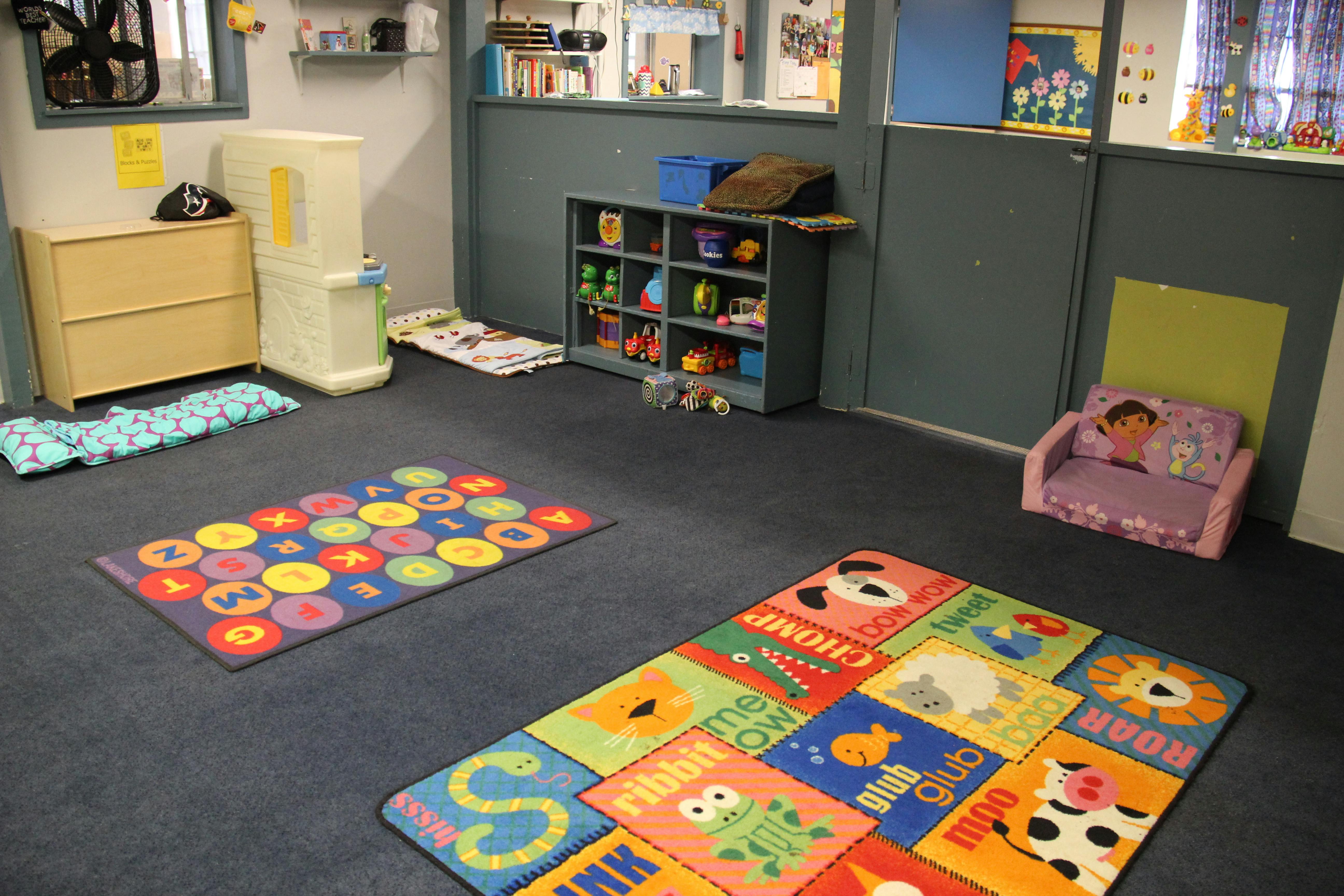 Playroom with colorful alphabet and number rugs on the floor