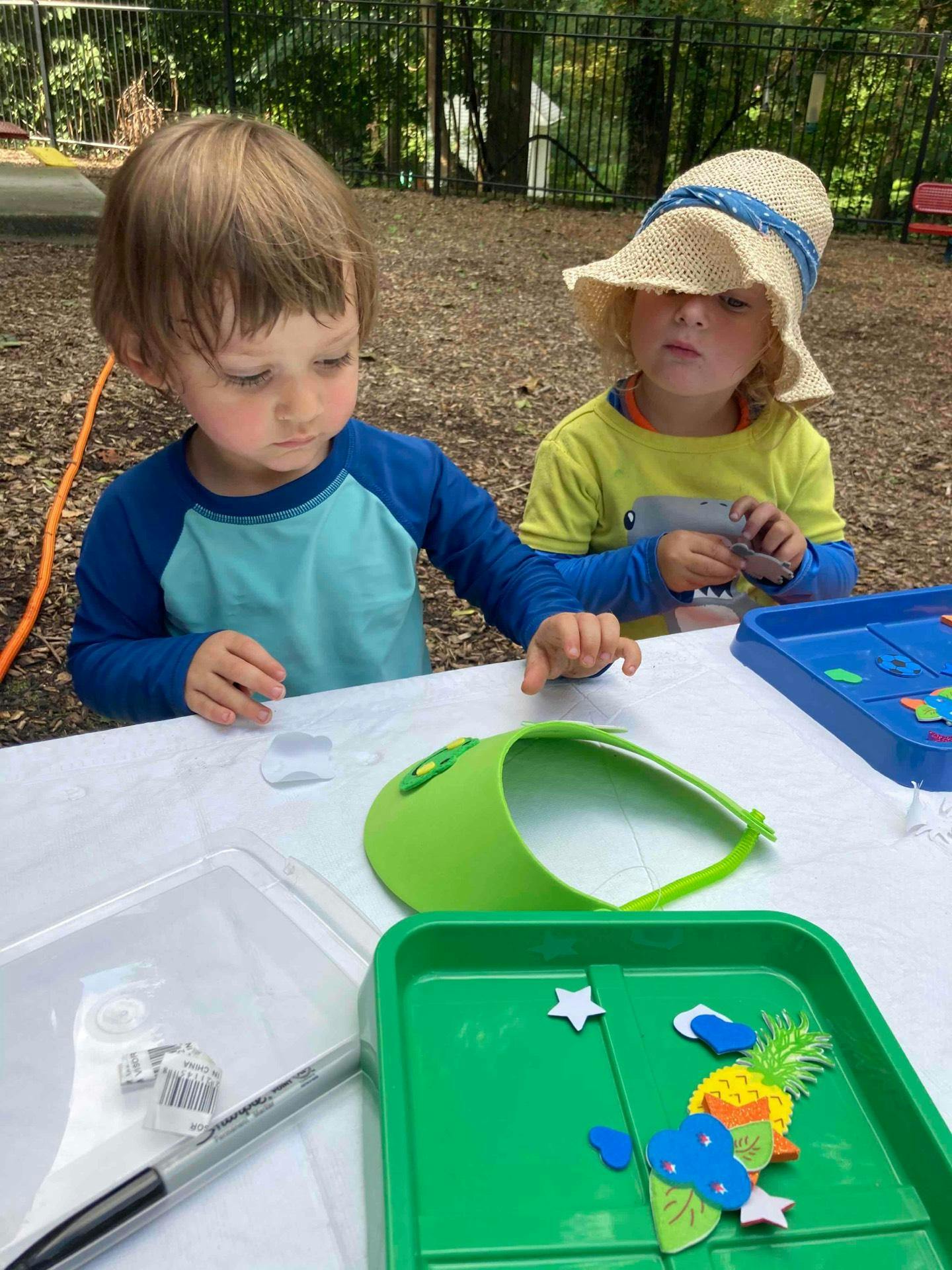 Two children at a table with craft supplies