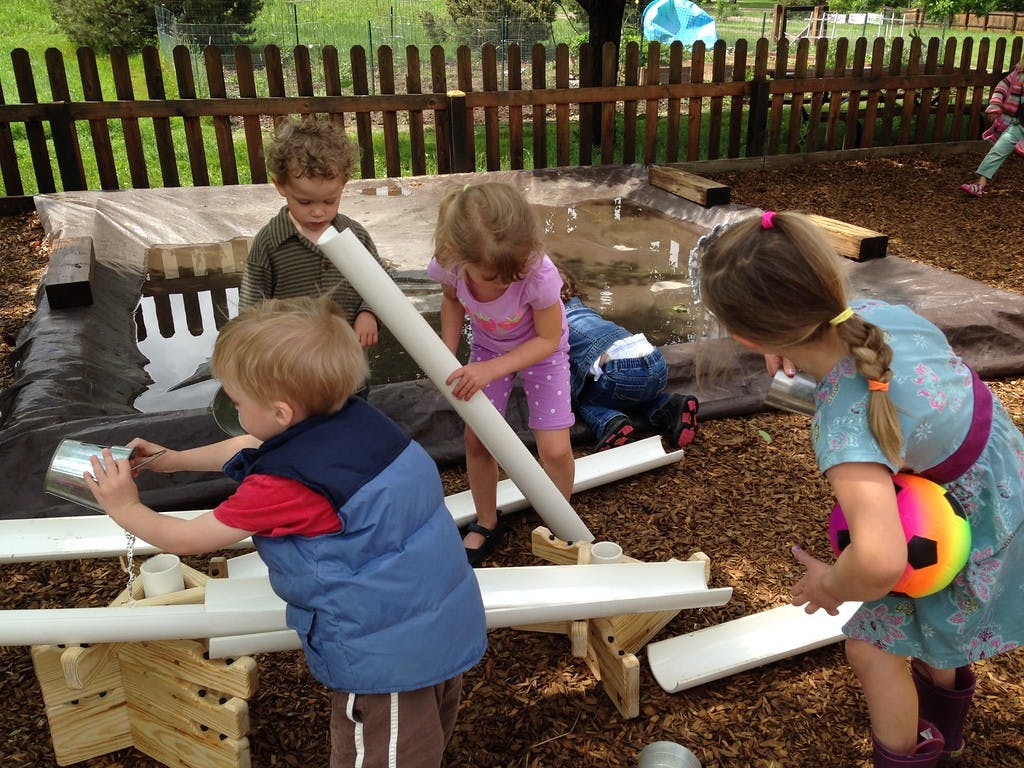 Children playing with water and pipes outdoors