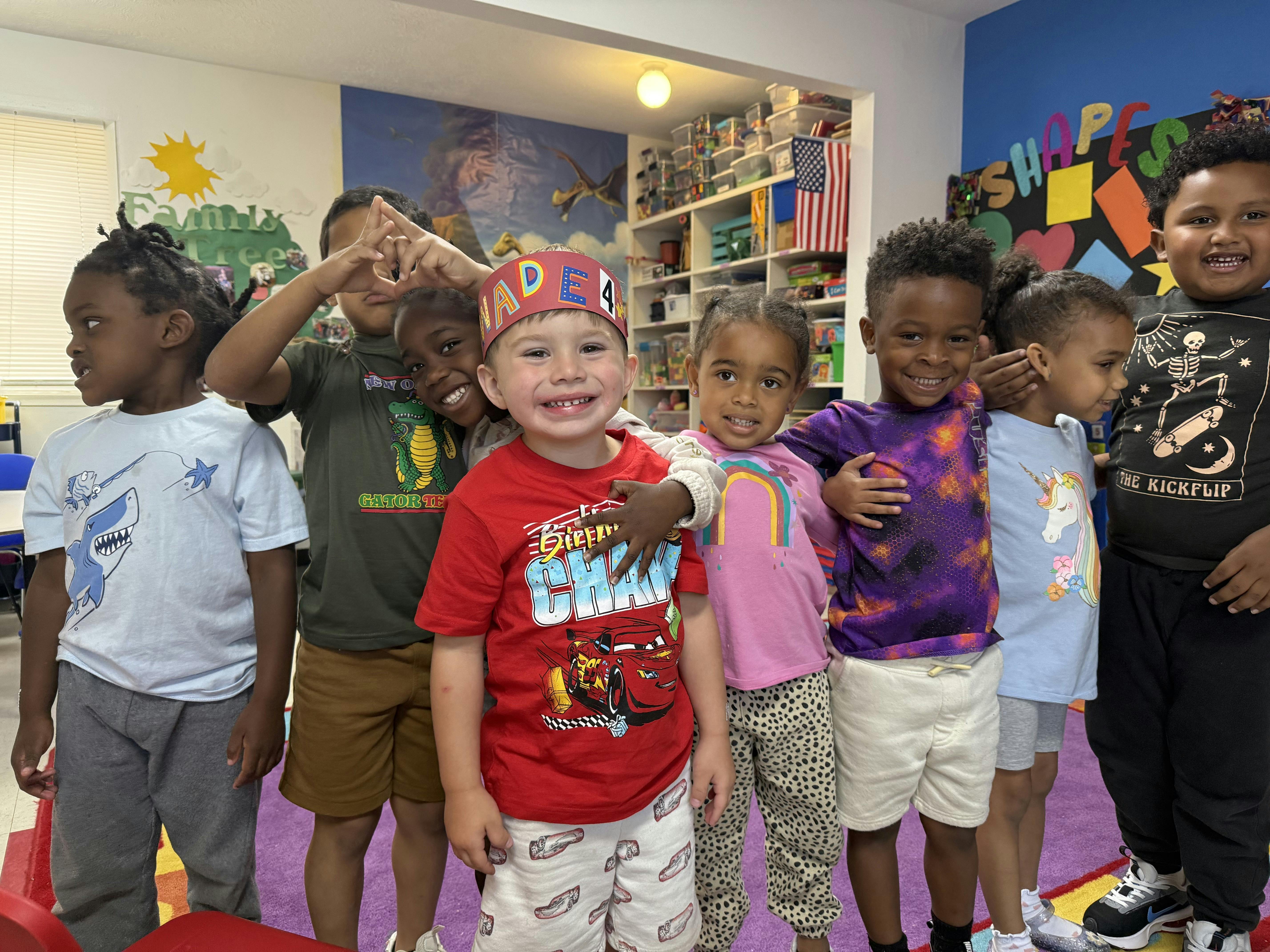 Group of children posing together in a classroom