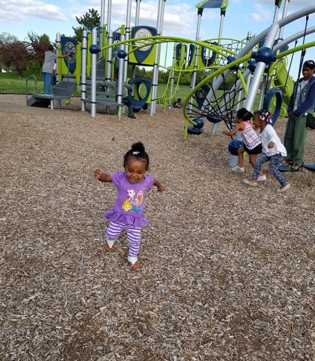 Child running on wood chips at a playground