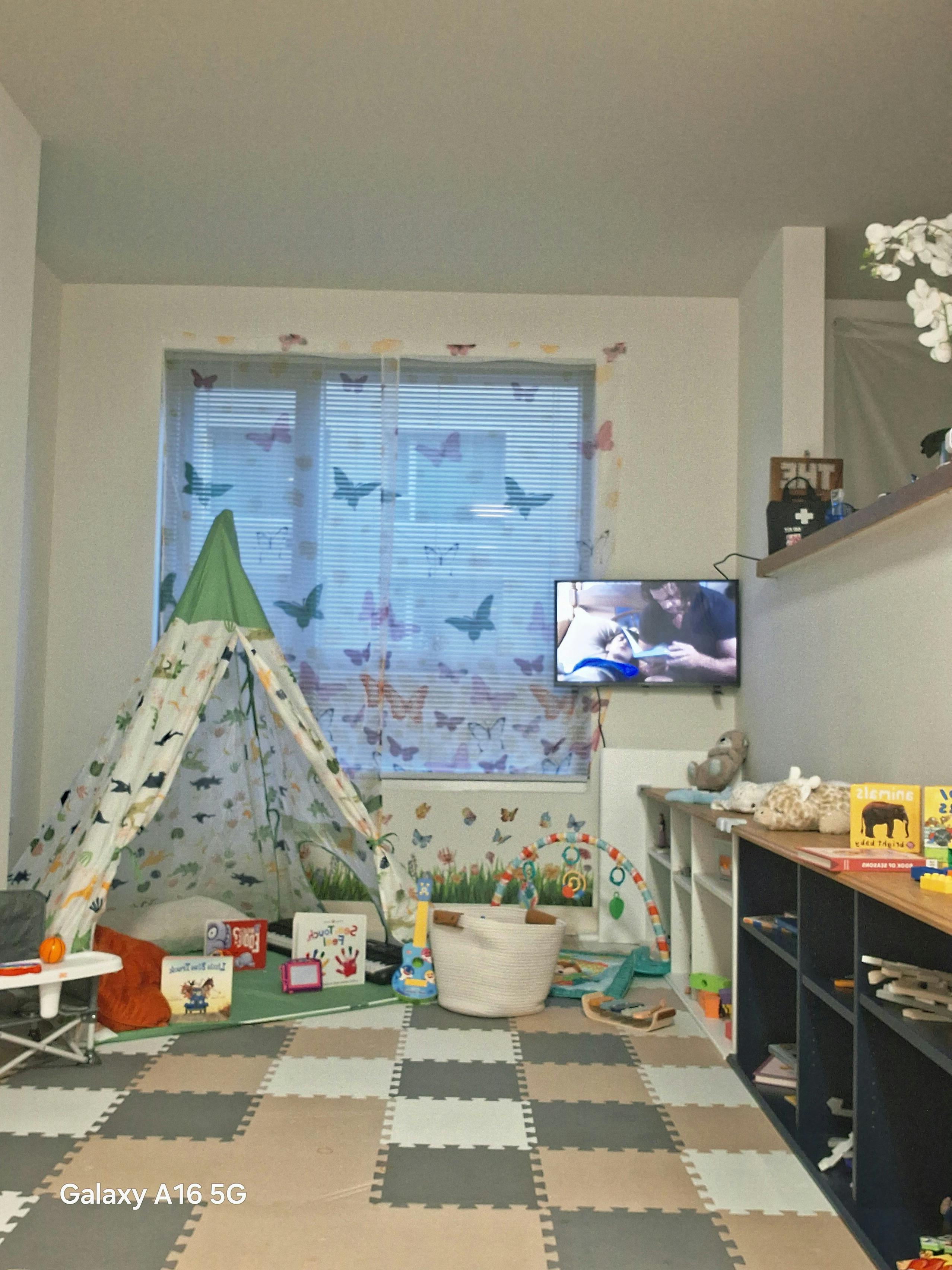 Playroom with a teepee, toys, and a television