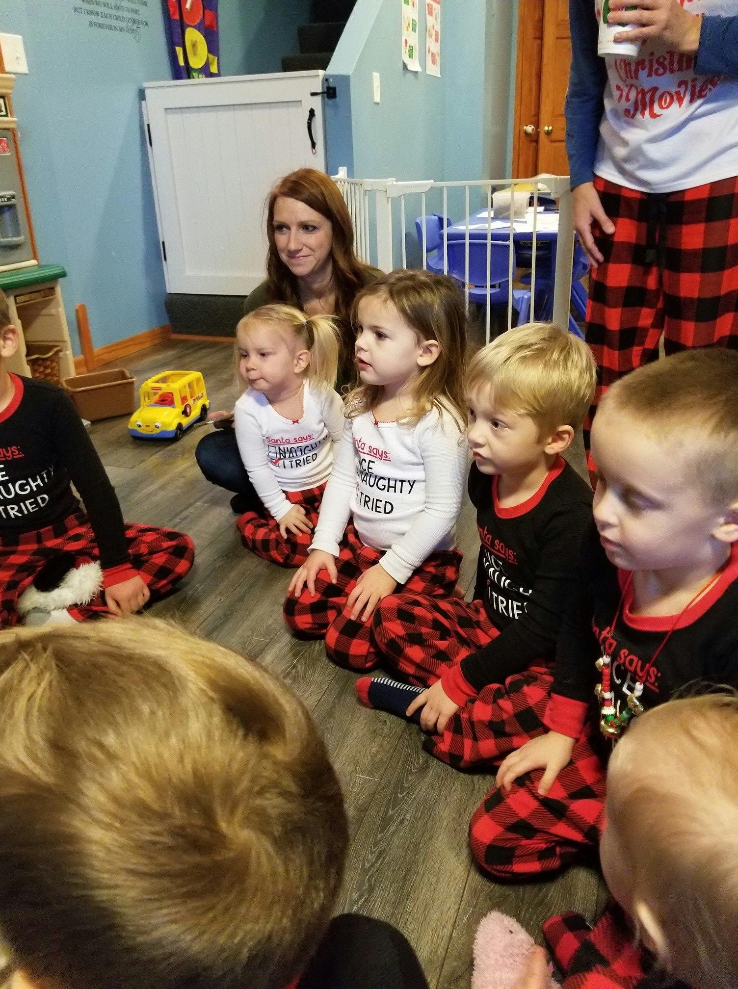 Adult and children sitting on the floor in a classroom