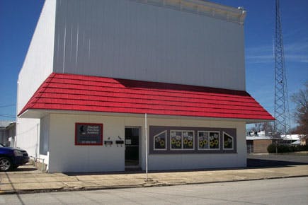 Building with a red awning and white facade