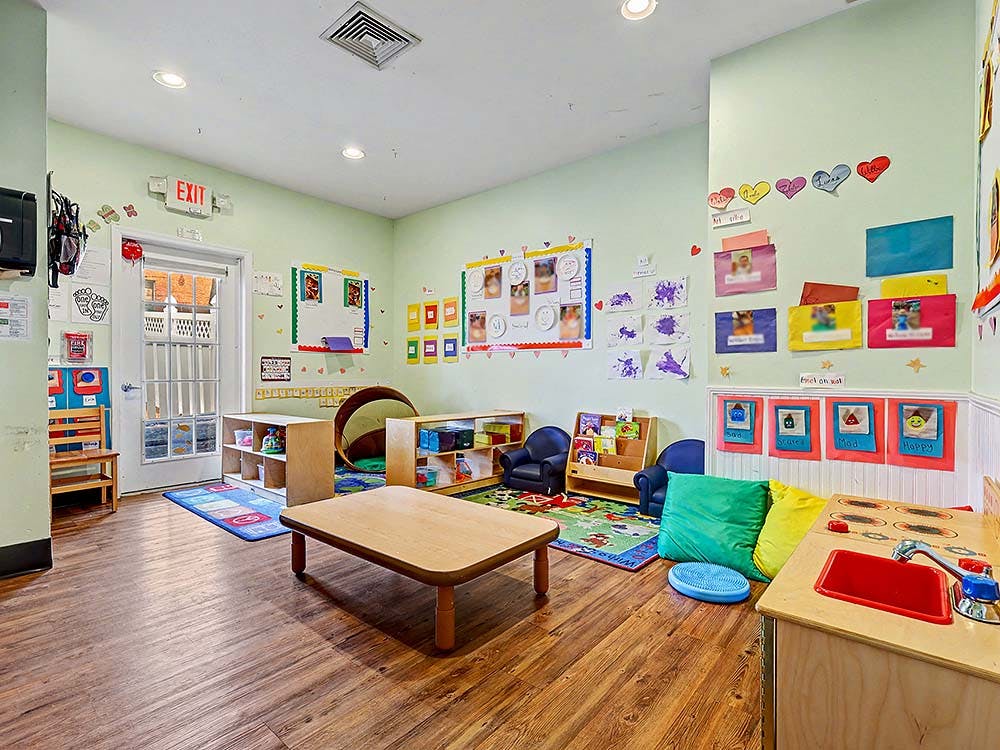 Children's classroom with small tables, chairs, and colorful decorations