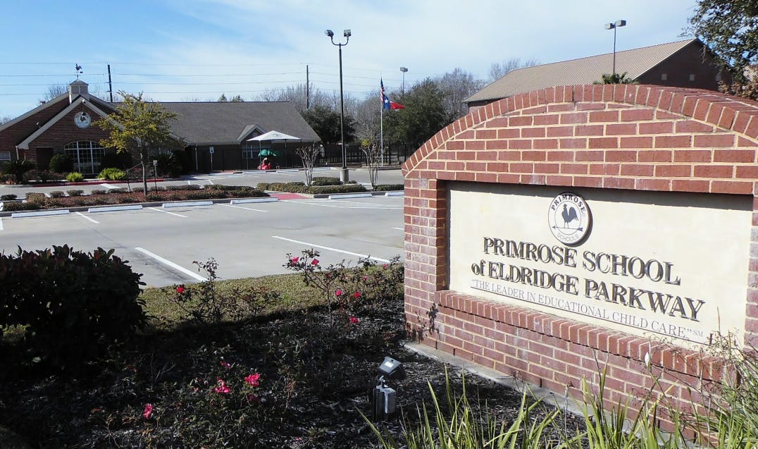 Brick sign for Primrose School at Eldridge Parkway with building in background