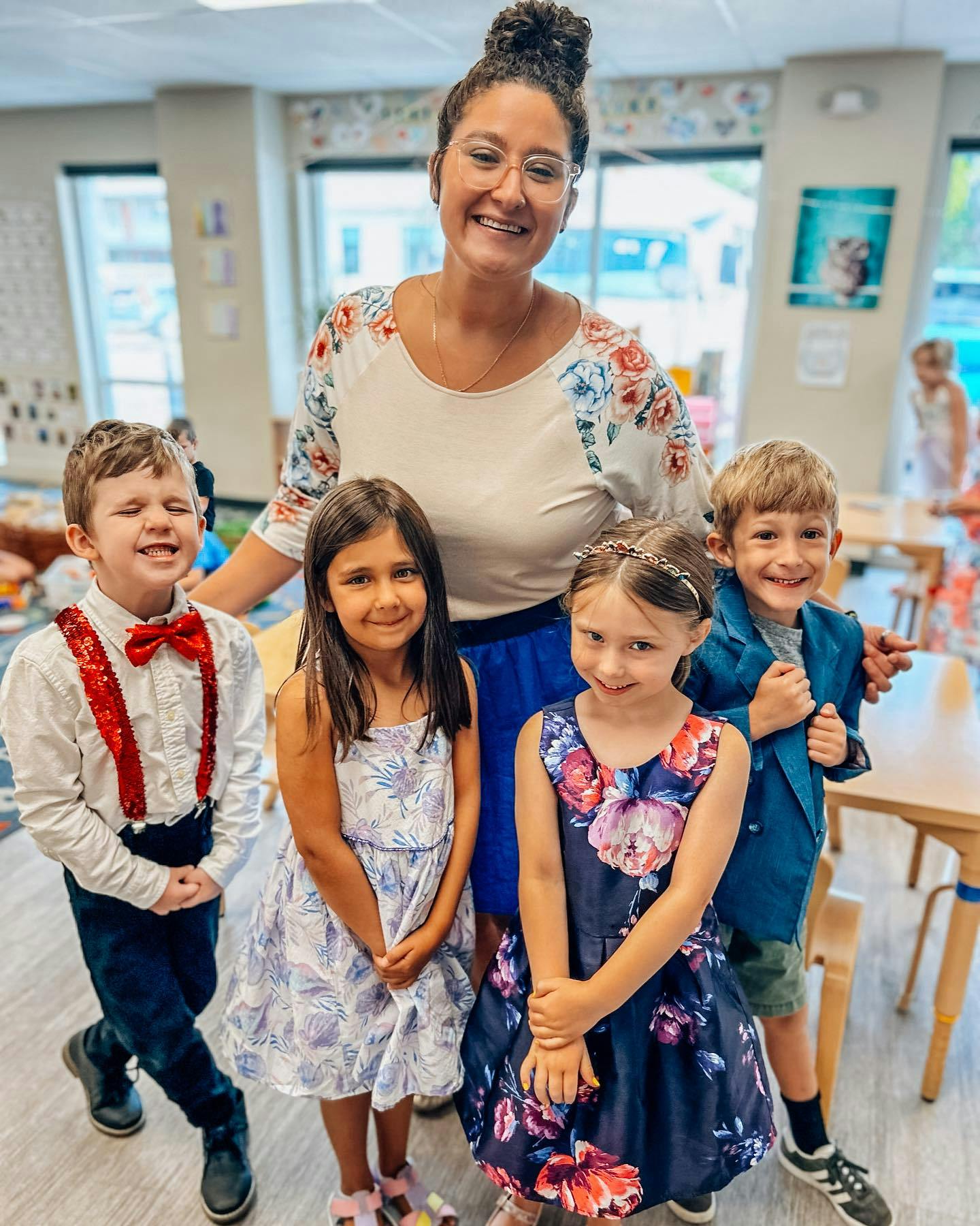 Adult person with four children in a classroom