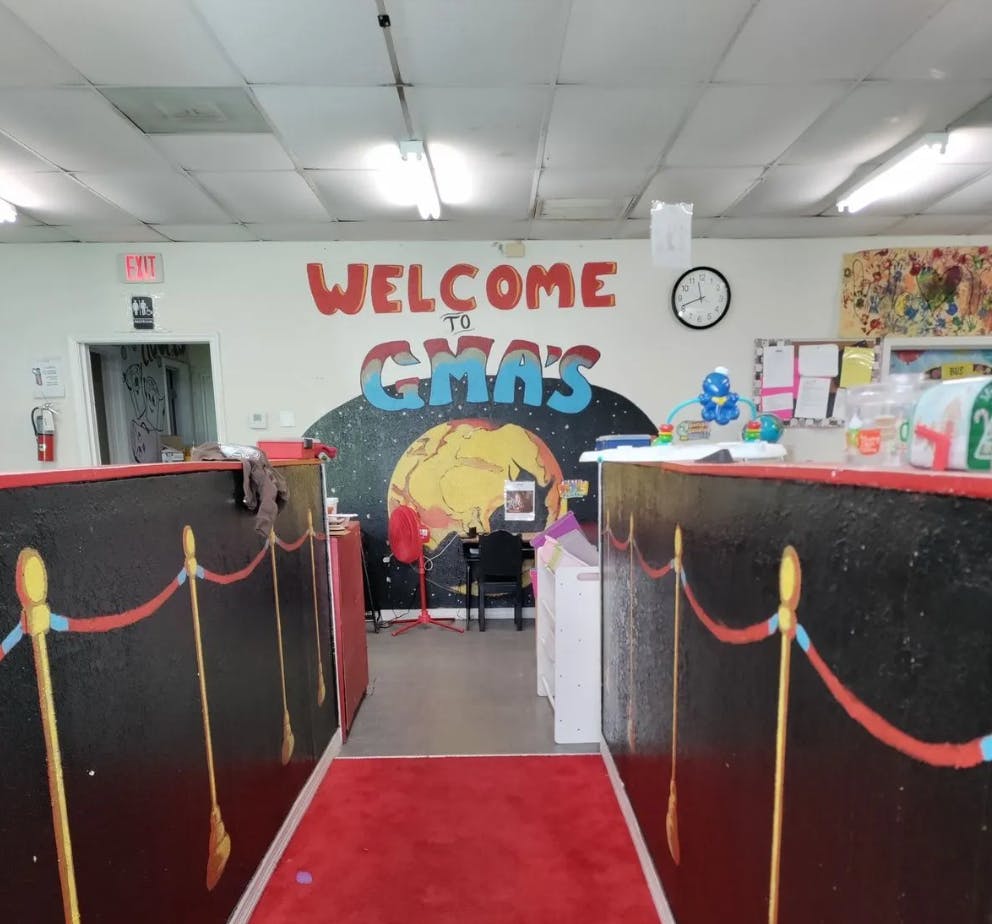 Red carpet leading to a wall mural that says "Welcome to GMA's"