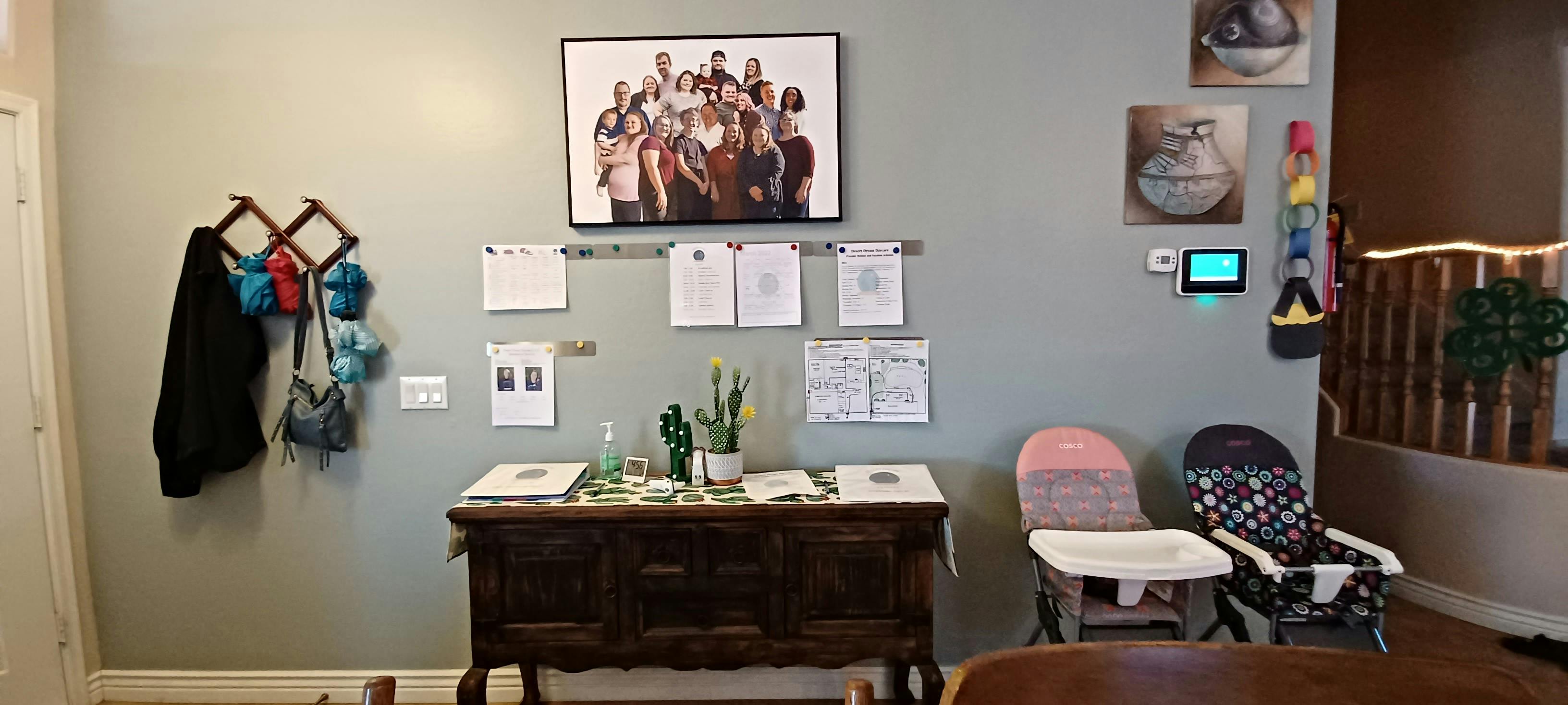 Wall with coat rack, framed picture, documents, and wooden console table