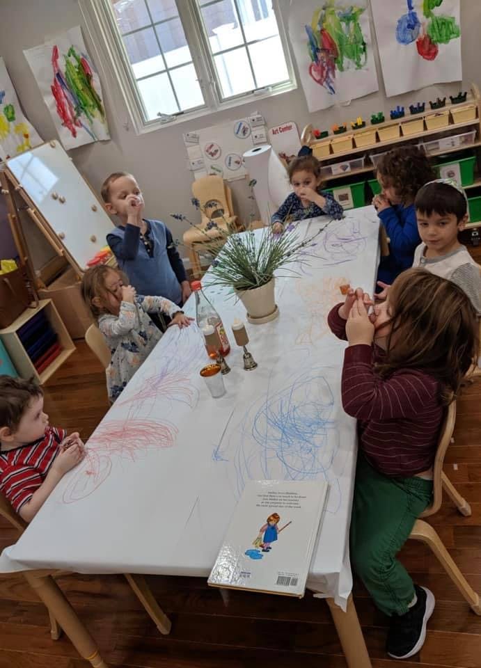 Children sitting around a table with drawings on the tablecloth