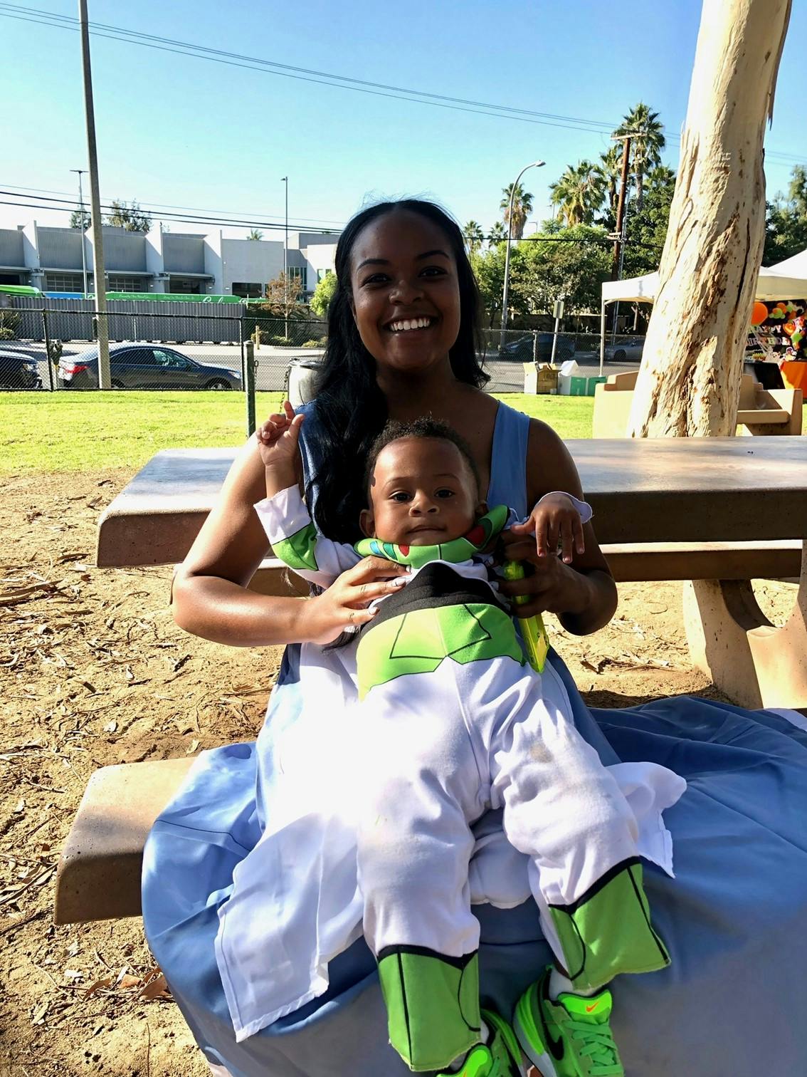 Person holding a child dressed in a costume