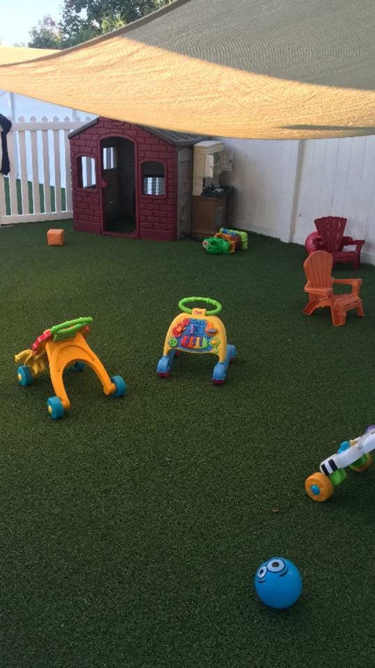 Playground with artificial turf, playhouse, and various toys