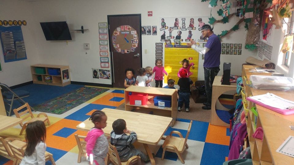 Adult standing with children in a classroom