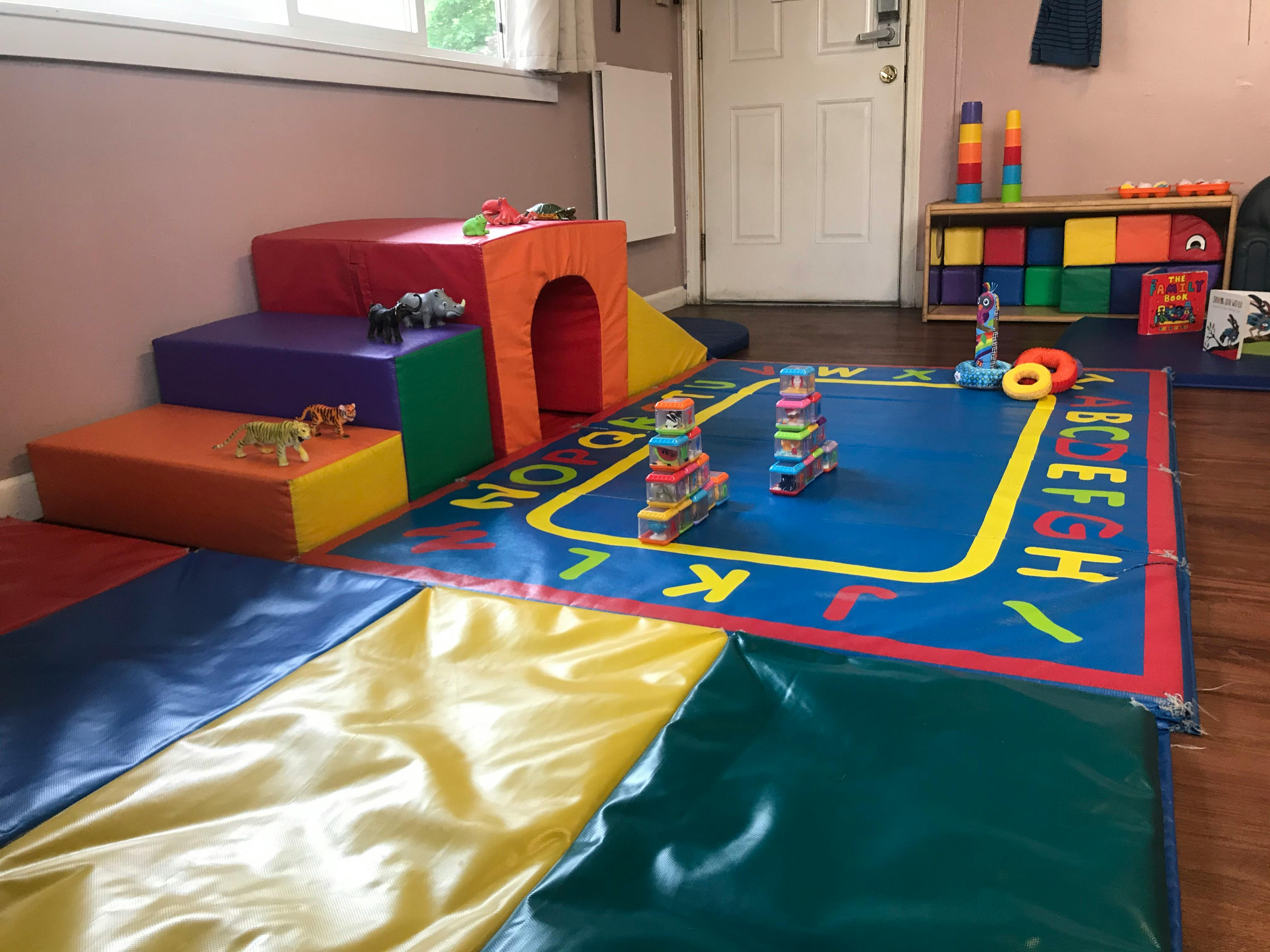 Indoor play area with soft play equipment and an alphabet mat