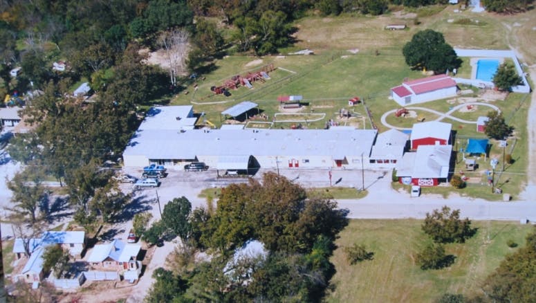 Aerial view of a large building complex with a swimming pool and trees