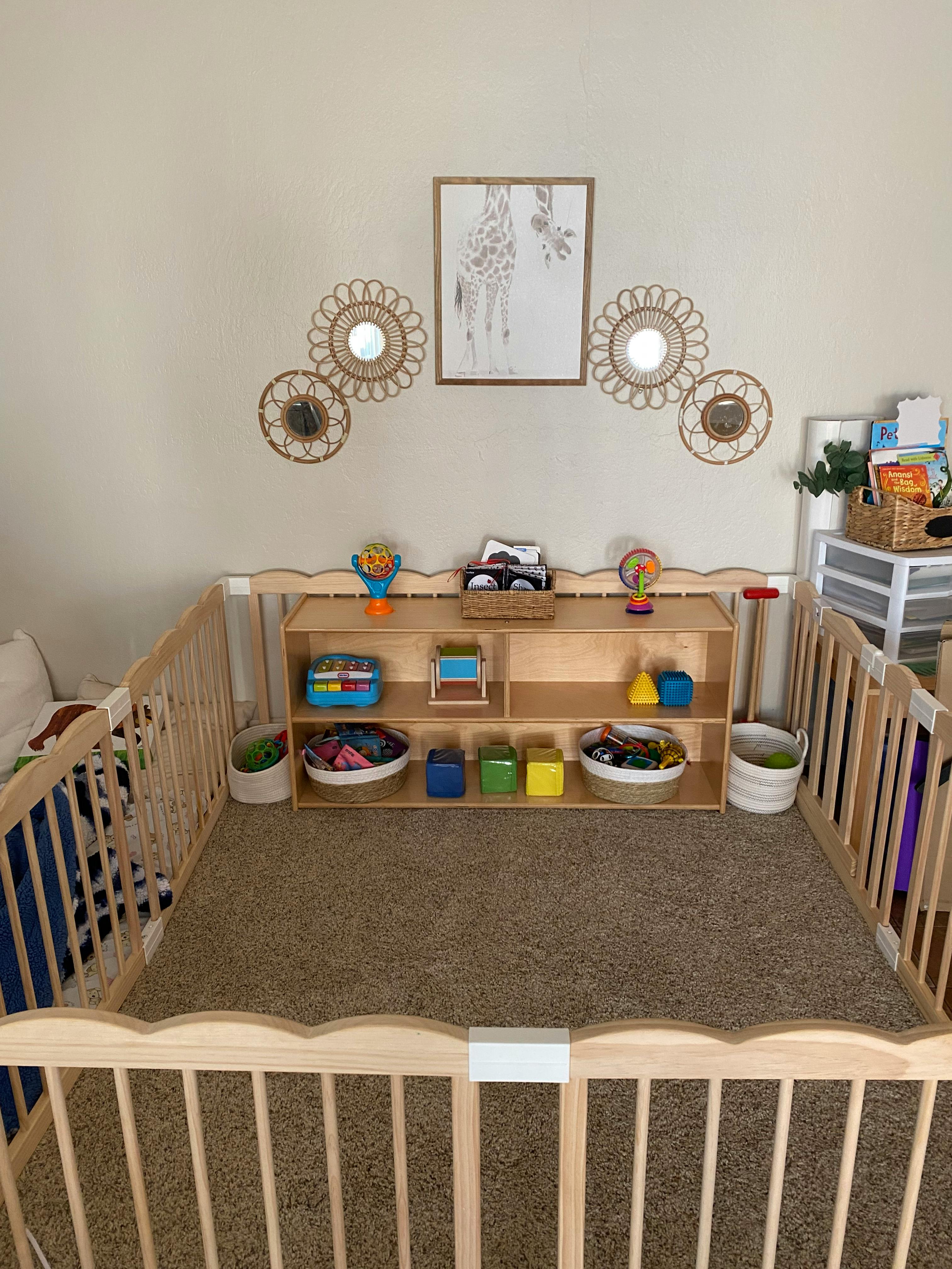 Playpen with a wooden shelf filled with toys and baskets