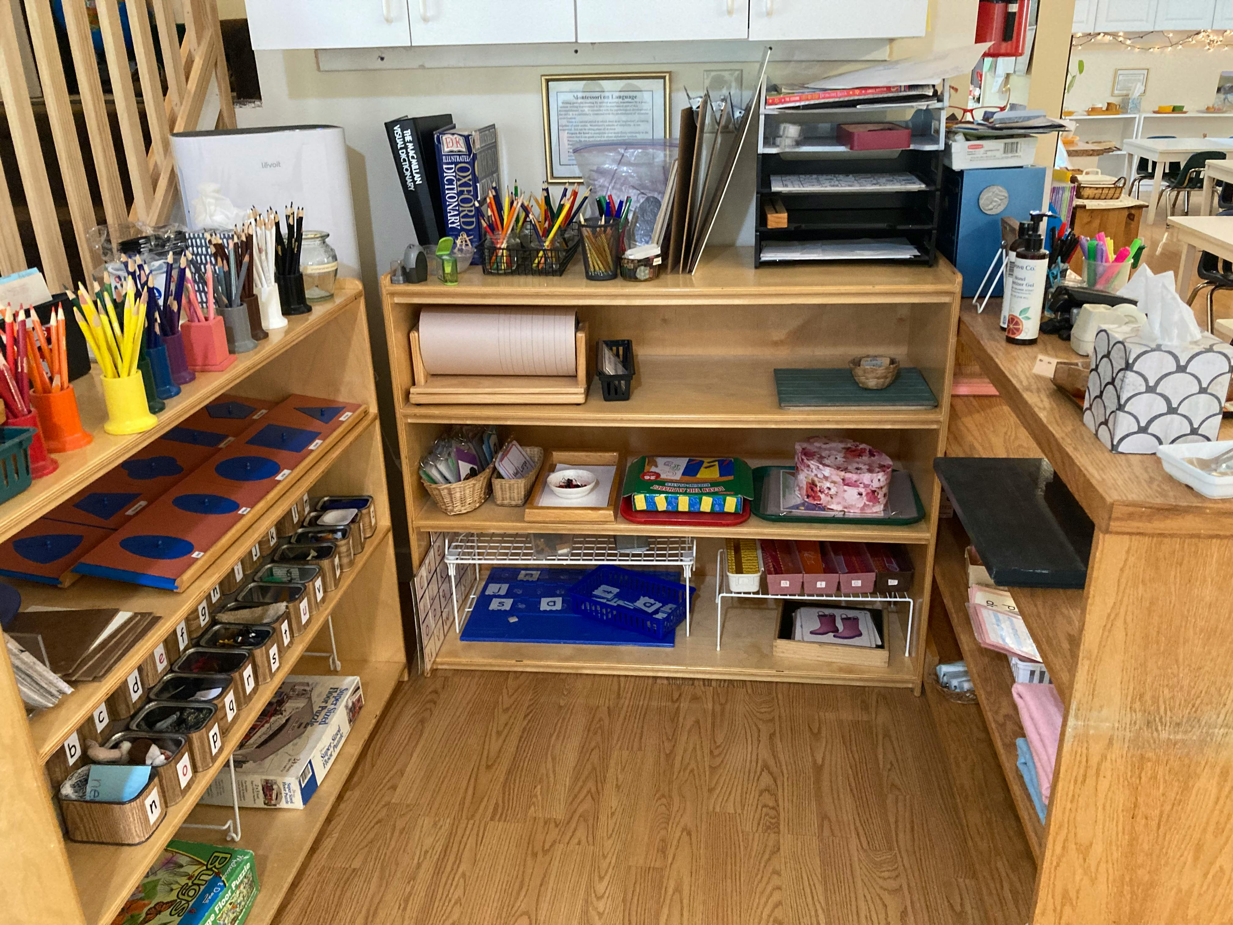 Classroom with wooden shelves filled with art supplies and learning materials
