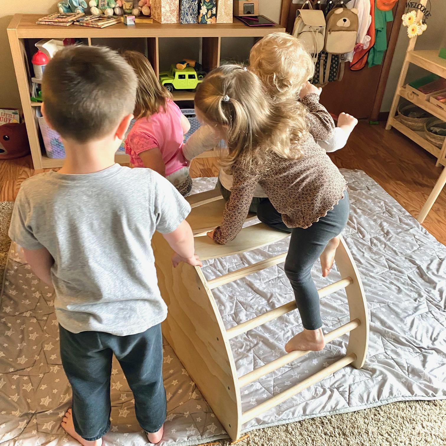 Children playing on a wooden climbing arch