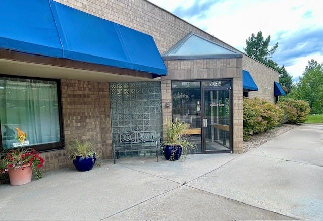 Building exterior with blue awnings and glass entrance